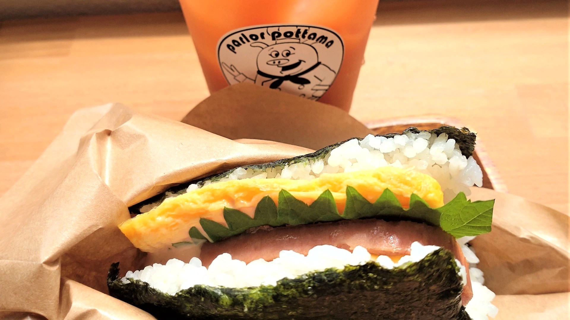 ぽったまのポークたまごおにぎり「オリジナル」（330円）とグァバジュース（320円）のセット写真。