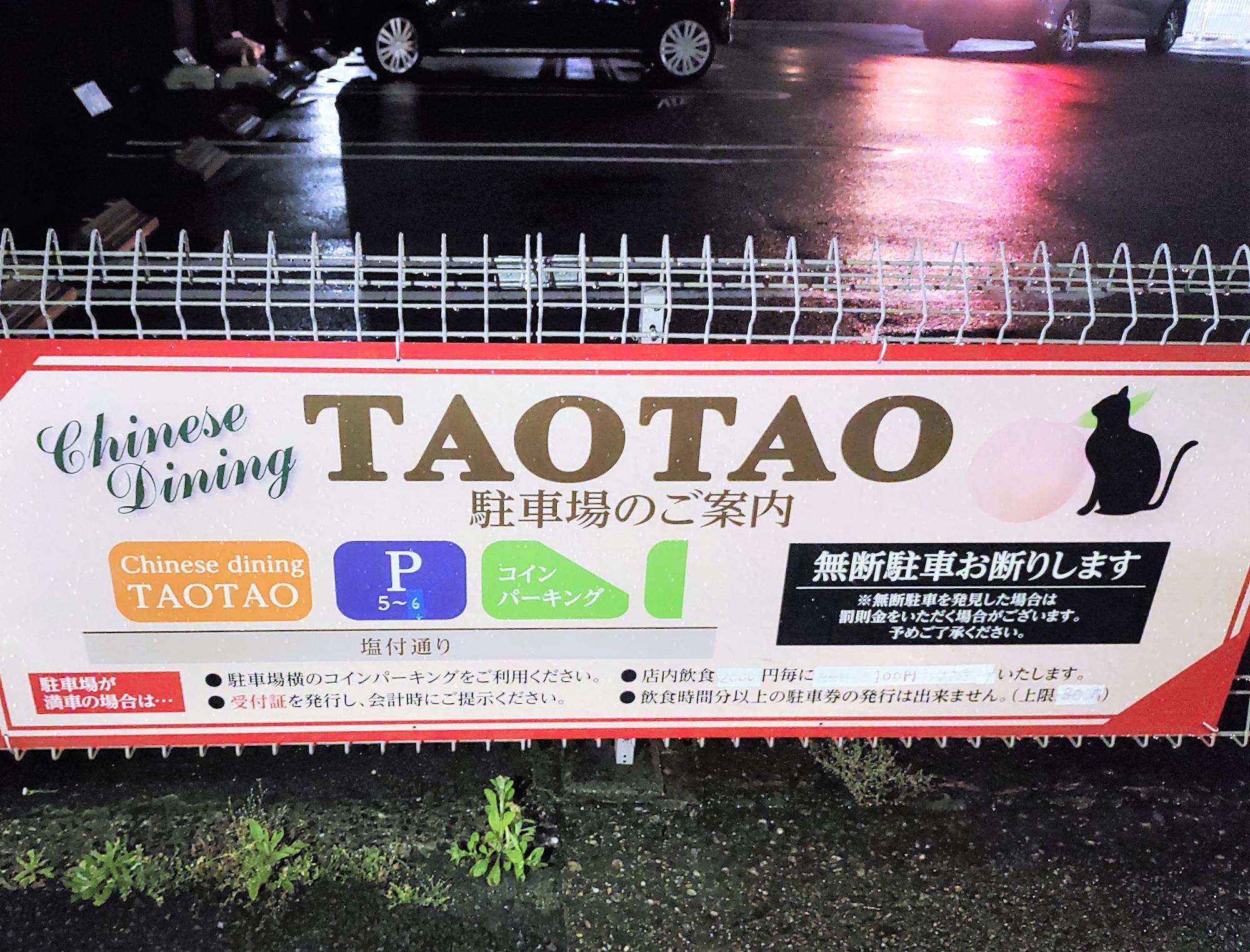 TAO TAO の駐車場案内看板。フェンスに掲示された駐車場番号や利用案内が写っている。