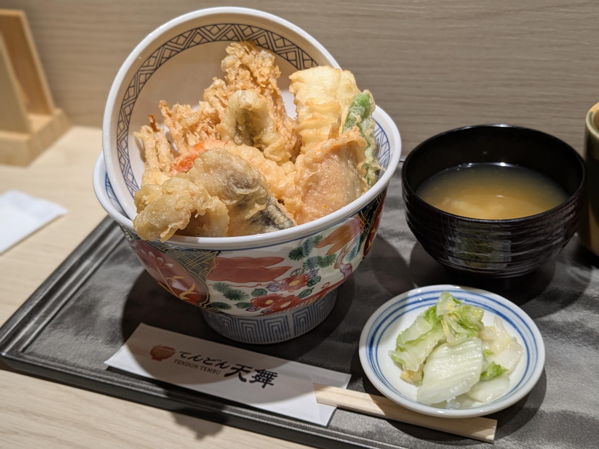 天丼専門店『天舞』の天丼セット。海老や野菜の天ぷらが盛られた天丼に、味噌汁と漬物が添えられている。