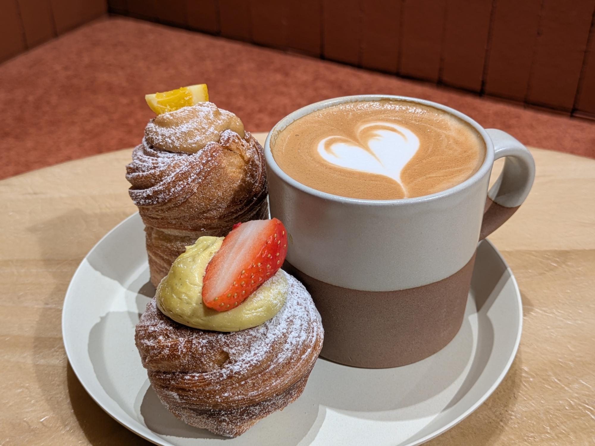 『Phi』のスイーツとラテのセット。苺をのせたスイーツと、ハートのラテアートが描かれたコーヒーが並ぶテーブル。