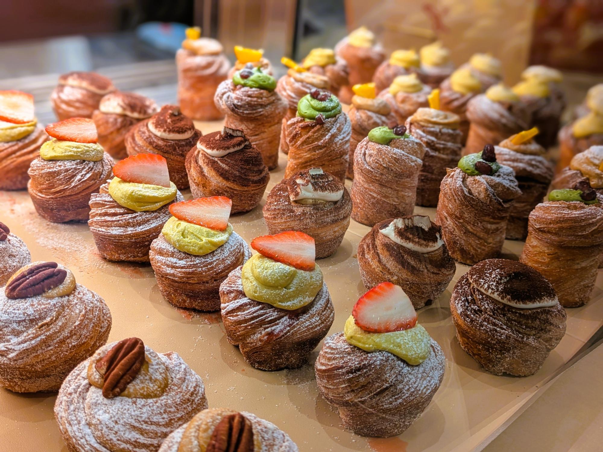 マルエイガレリア『Phi』のショーケース。苺やナッツ、クリームをのせた華やかなスイーツが並ぶ様子。