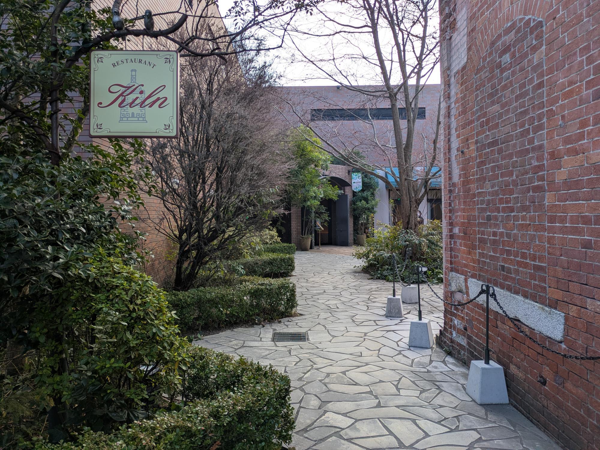 ノリタケの森「キルン」レストラン入口の看板と緑の小径 