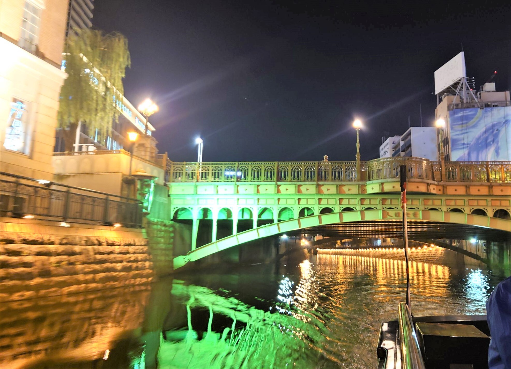 ライトアップされた橋が水面に映る、夜の堀川の風景 