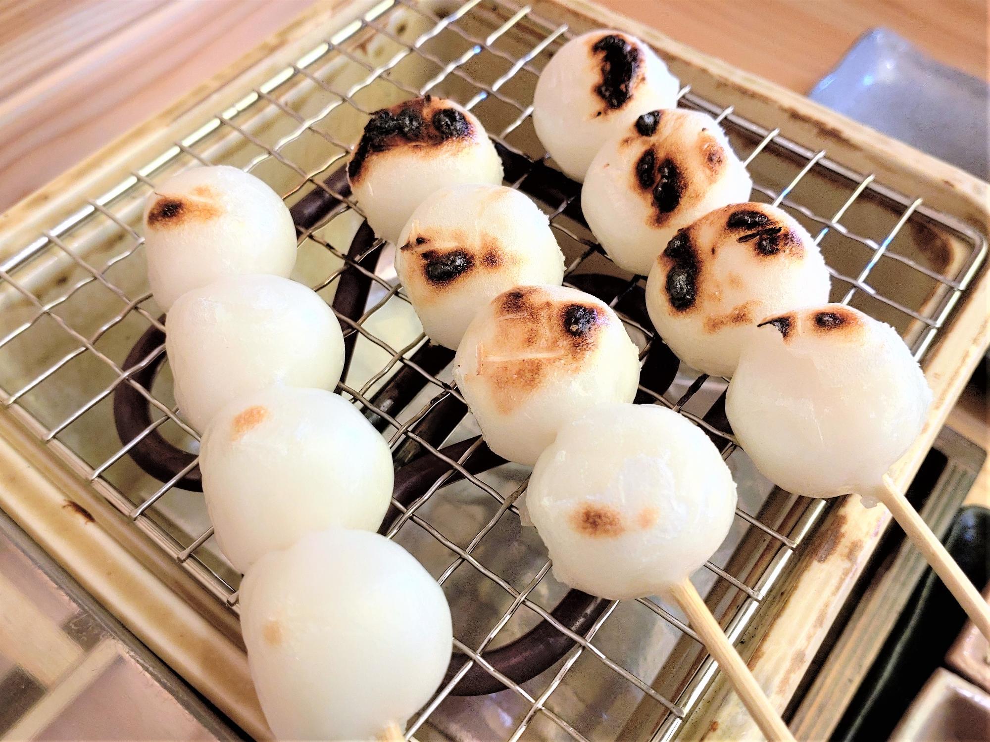 おかげ庵で自分で焼く串団子。こんがりと焼き目がついた団子が網の上で並ぶ様子。