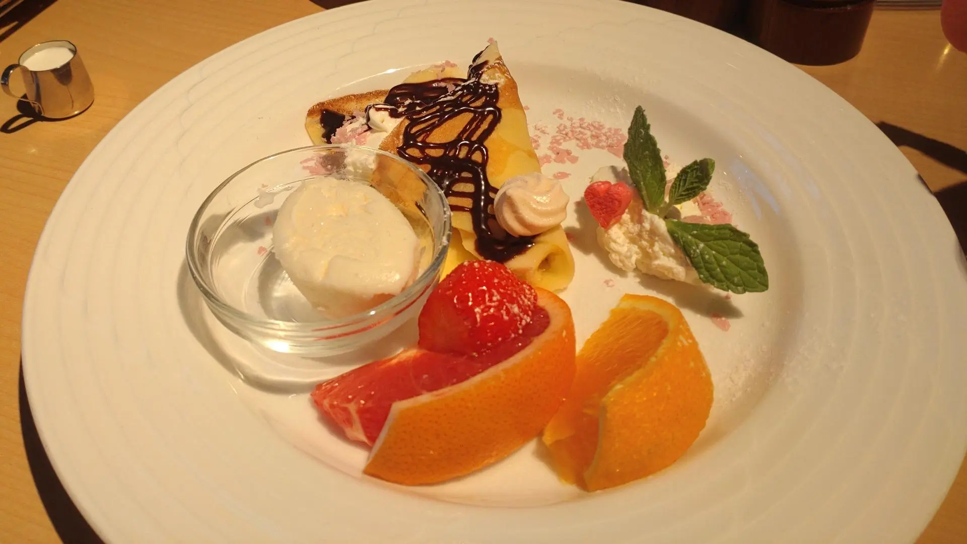 クレープにアイスクリームとフルーツ、ホイップクリームを添えた華やかな盛り合わせ