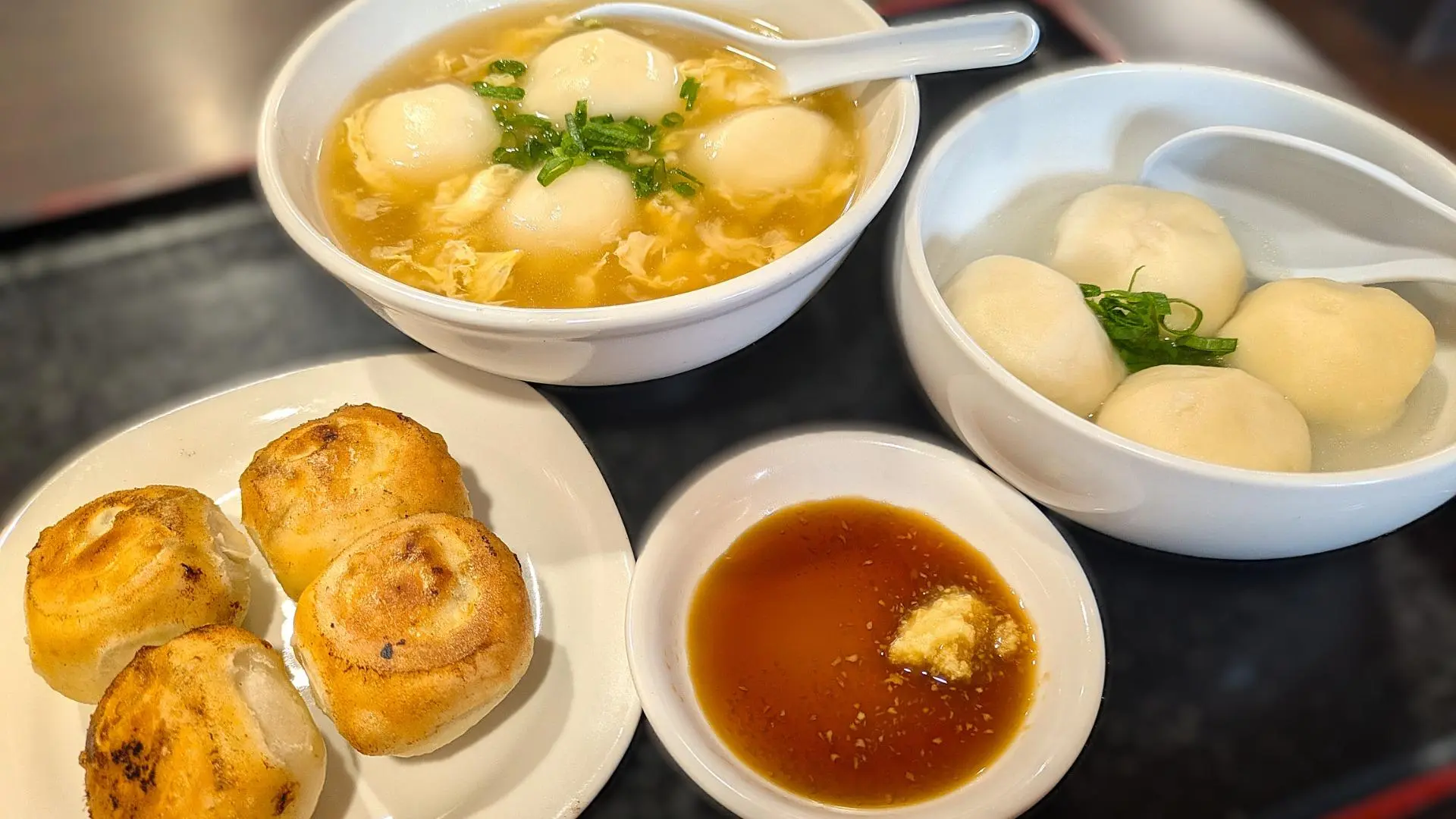 情熱ギョーザの欲ばりセット。餃子と水餃子、スープ餃子が並ぶ定食のアップ写真