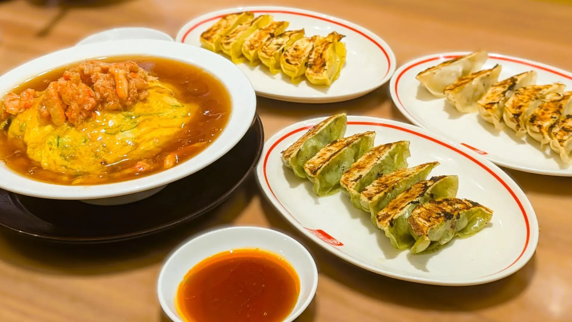 藤一番の餃子3種と、蟹天津飯が並ぶテーブルの様子。