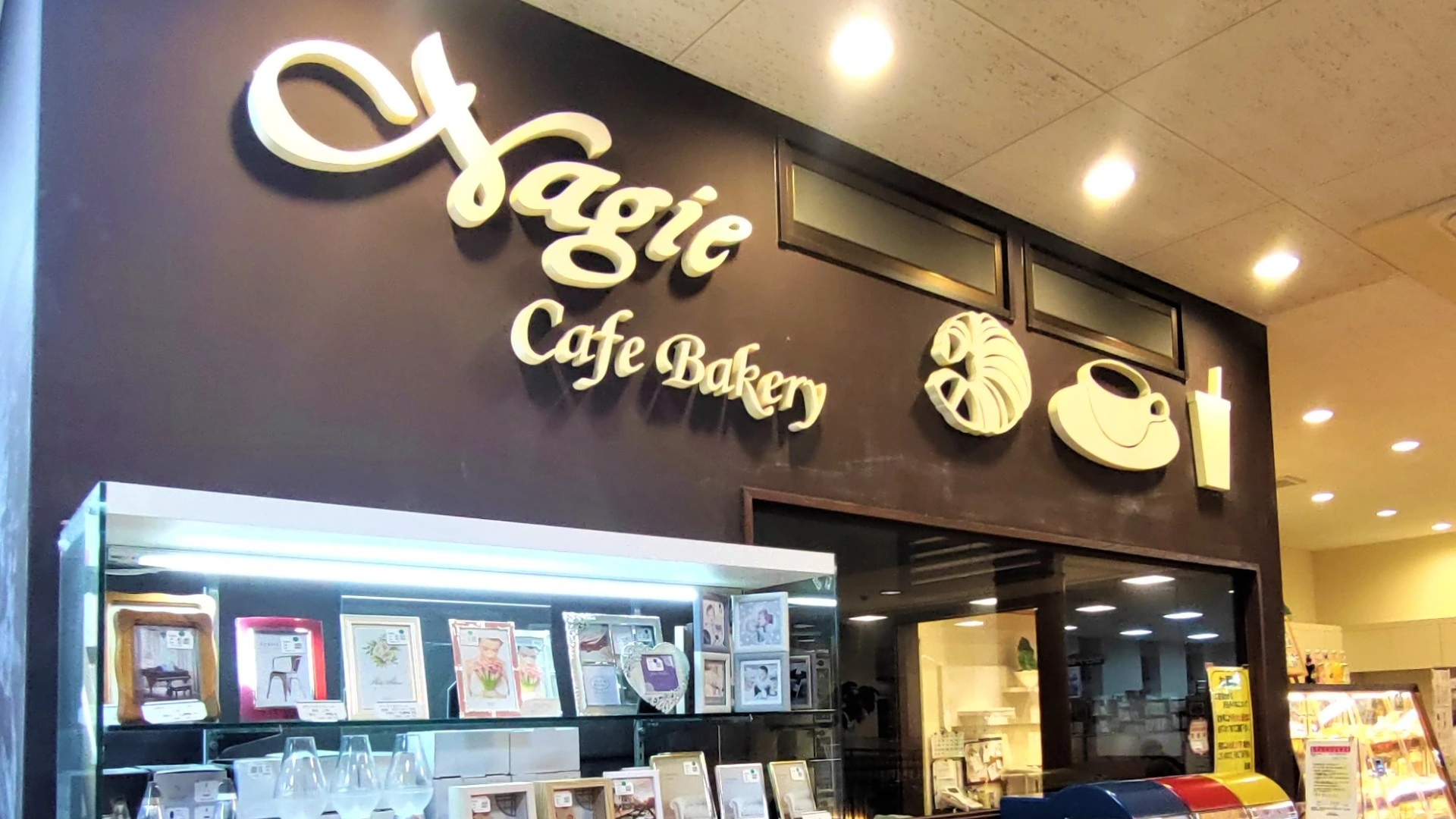 名古屋市千種区のカフェベーカリー「ナギー」の店頭看板。パンとカフェのアイコンが並ぶ落ち着いた雰囲気の入口。