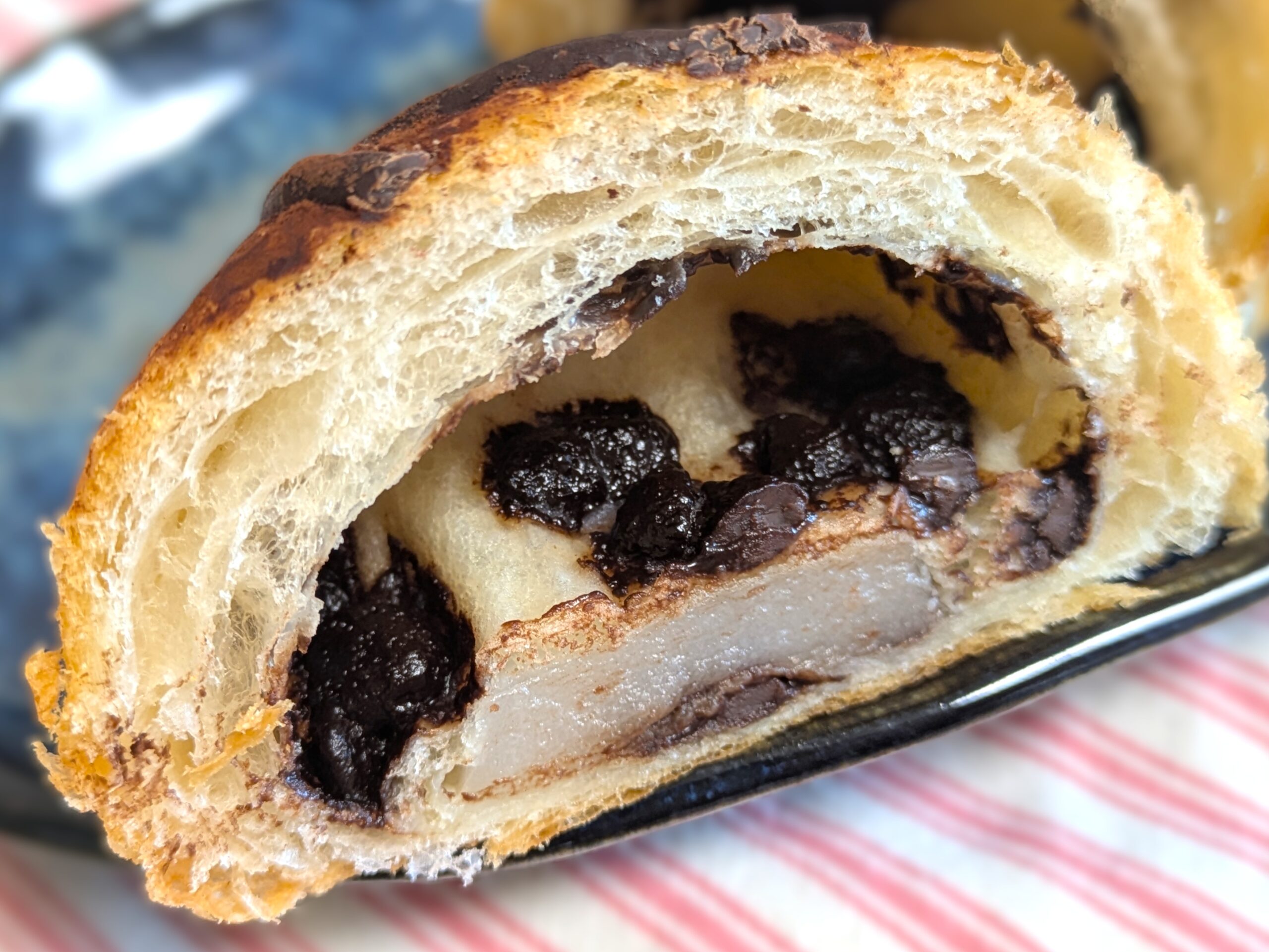 チョコクロッチの断面。サクッとした生地の中にチョコチップと餅が混ざり、層の質感がわかるアップ写真。