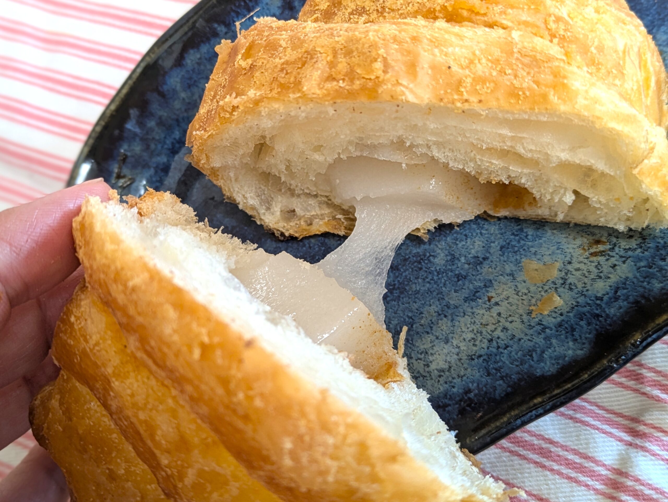 割ったクロッチの中から、お餅がとろりと伸びる様子。サクッとした層ともちっとした食感が伝わるアップ写真。