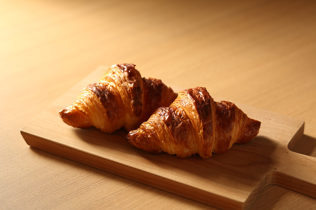 木のボードに並んだクロワッサンの公式イメージ。