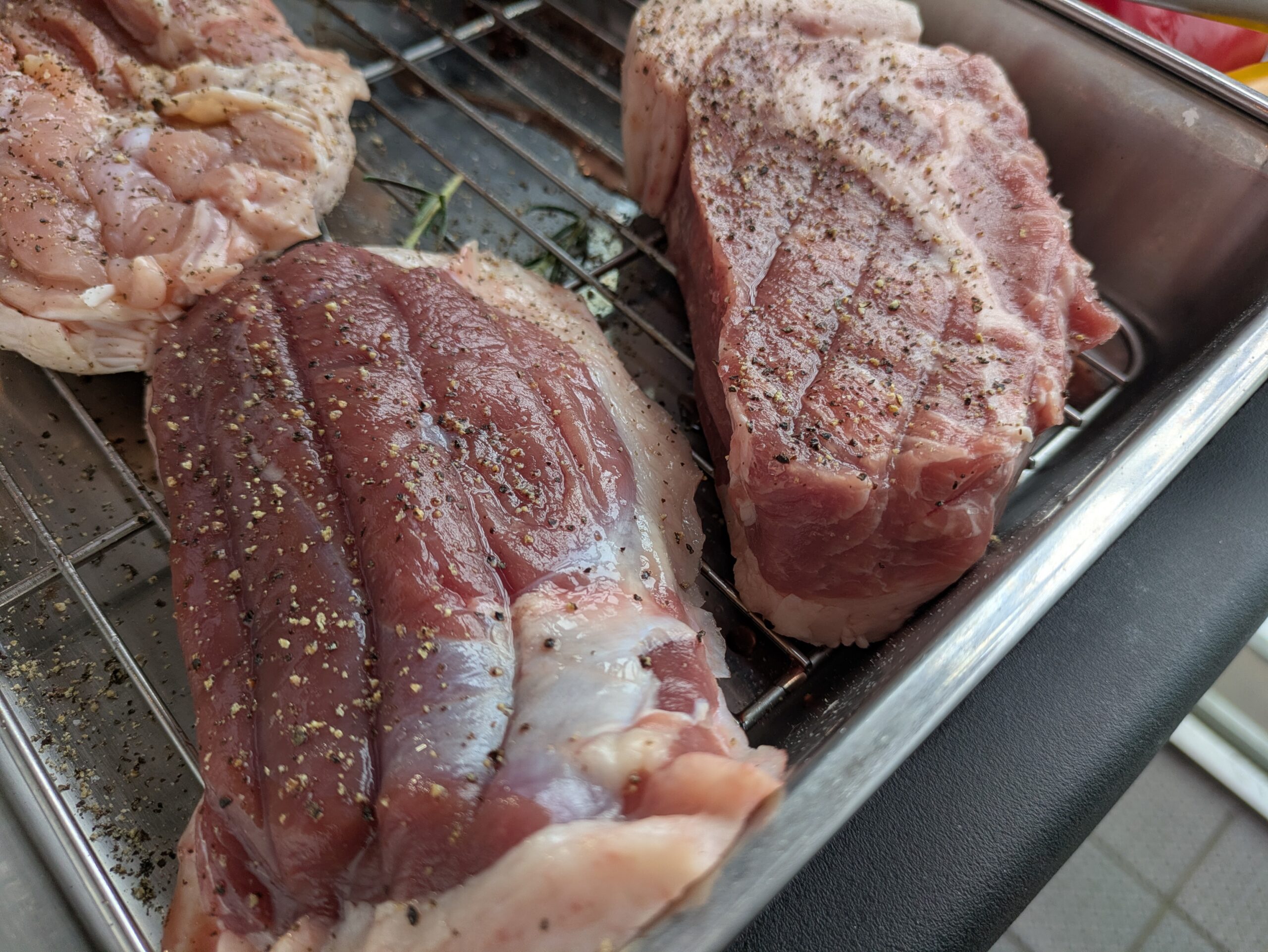 CARVINOで提供されるBBQ用の厚切り肉を、金網に並べた調理前の様子。